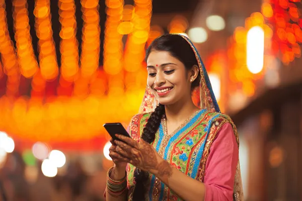 একজন পুরুষ তার ল্যাপটপে মনোযোগ দিয়ে কাজ করছেন, ব্যাকগ্রাউন্ডে লাইভ স্ট্যাটস — যা 777D মোবাইল অ্যাপের স্পোর্টস ও গেমিং ফিচারগুলোকে তুলে ধরে।